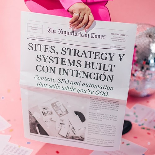 Flat-lay of a pink-suited woman holding a newspaper that reads “Sites, Strategy y Systems Built con Intención™ – Content, SEO and automation that sells while you’re OOO.” A disco ball and colorful confetti accent the frame.