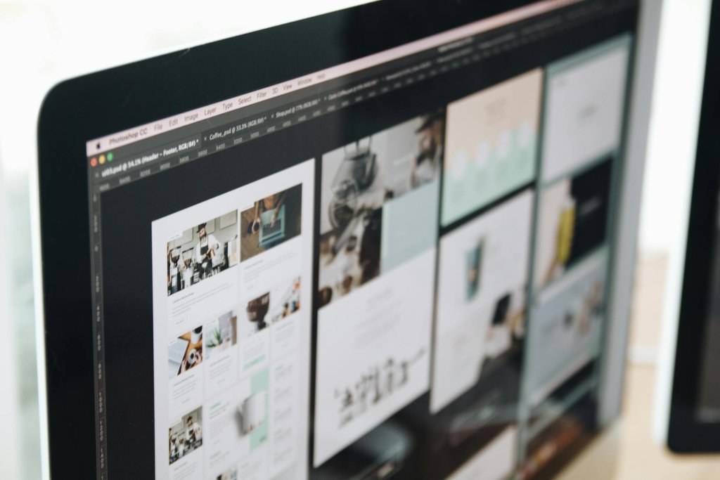 A desktop monitor displays multiple website page layouts arranged side by side during a design process. The image shows visual planning and structure work involved in organizing website content and improving user experience.